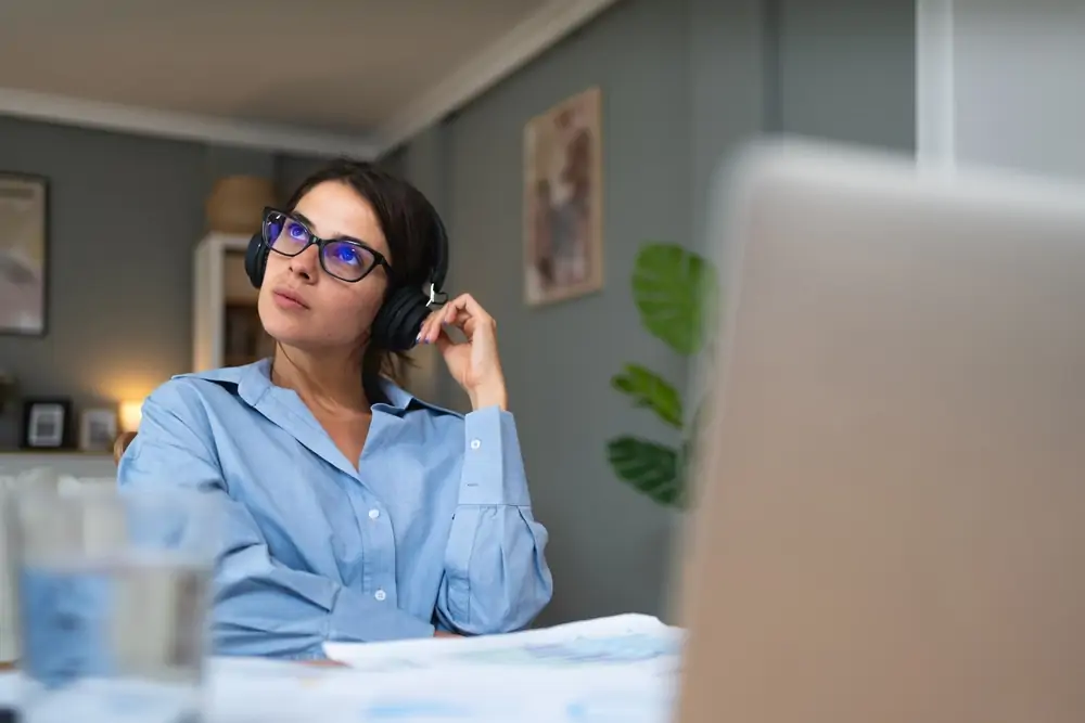 A girl listening to headphones at her computer
