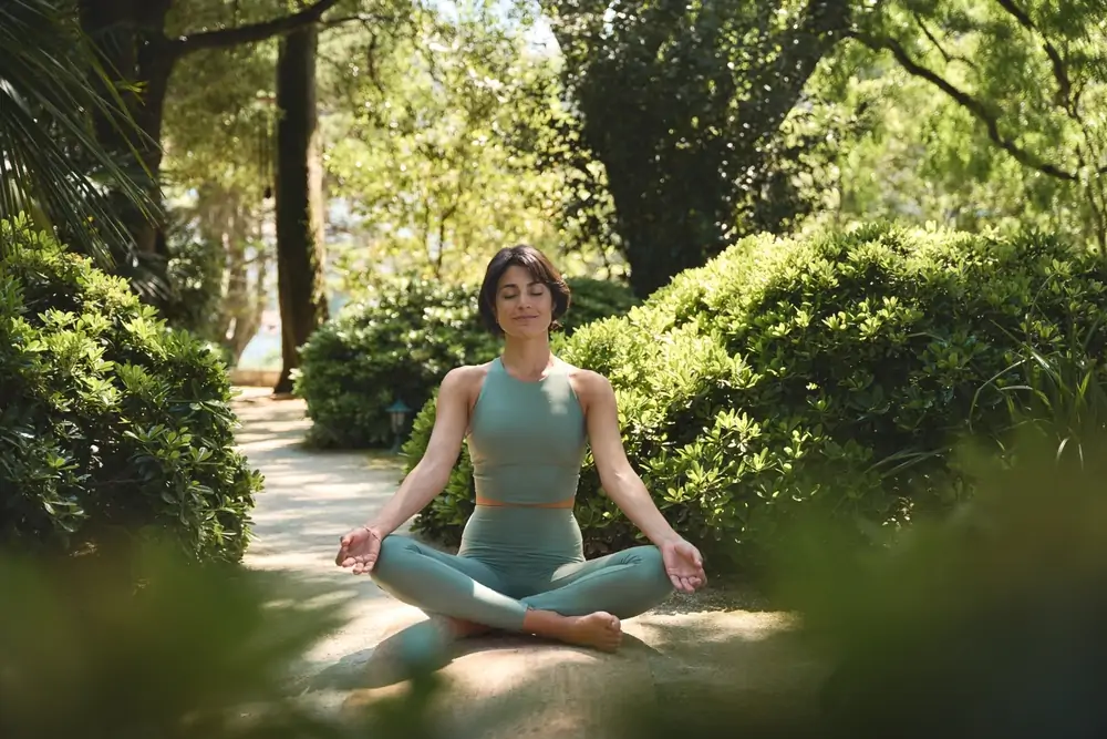 A young woman meditating on a nature path